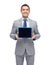 Happy businessman in suit showing tablet pc screen