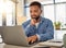 Happy businessman working on his laptop at home. Handsome businessman reading an email on his laptop at home. Freelance