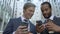 Happy businessmen using easy mobile app on smartphone, colleagues on lunch break