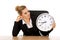 Happy businesswoman with clock behind the desk