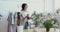 Happy businesswoman in glasses watering flowers at workplace.