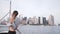 Happy businesswoman with hair blowing in the wind watching epic Manhattan skyline view in New York on a boat slow motion