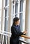 Happy businesswoman leaning on railing in office