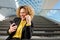 Happy businesswoman sitting on stairs looking at mobile phone