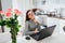Happy businesswoman talking working on laptop on modern kitchen. Freelancer relaxing and smiling at camera