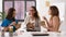 Happy businesswomen eating take out food at office