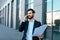 Happy busy confident handsome businessman with beard in suit works with documents and calls by smartphone