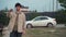 Happy buyer holds the keys near a new white car