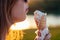 Happy californian beautiful woman in sunflasses eat ice cream in a waffle horn cone at sunset on the beach. cool