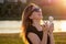 Happy californian beautiful woman in sunflasses eat ice cream in a waffle horn cone at sunset on the beach. cool