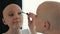 Happy cancer survivor woman putting on make up, looking in the mirror