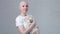 Happy cancer woman surviror smiling looking into the camera and holding cute little dog spitz - breast cancer awareness