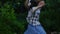 Happy candid woman listening music dancing outdoors in summer.