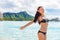 Happy carefree Asian tourist bikinig girl on Waikiki beach Hawaii travel holiday with open arms in freedom having fun in