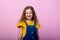Happy carefree child emotions. Energetic joyful adorable little girl laughing at joke on pink background