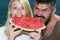 Happy carefree couple eat watermelon. Vitamins and healthy concept. Enjoying a watermelon. Couple friends eating a