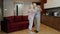 Happy carefree elderly senior grandparents in love dancing waltz in modern living room at home