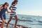 Happy carefree family running on beach at sea.