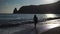 happy carefree sensual woman with long hair in black swimwear posing at sunset beach. silhouette of young beautiful