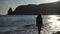 happy carefree sensual woman with long hair in black swimwear posing at sunset beach. silhouette of young beautiful