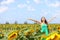 Happy carefree summer girl in sunflower field