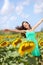 Happy carefree summer girl in sunflower field