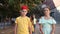 Happy carefree tweens girl and boy enjoying friendly conversation while walking down city street during summer vacation