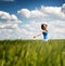 Happy carefree young woman in a green wheat field