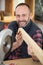 Happy carpenter with fret saw cutting wood plank at workshop