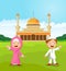Happy cartoon Muslim kids waving hand in front of mosque
