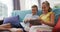 Happy caucasian brother and sister at home, sitting on couch using tablet together and smiling