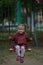 Happy caucasian child of two years old sitting on chain swing and swinging looking at camera