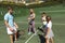 Happy caucasian couple with daughter and son outdoors, playing tennis on tennis court