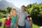 Happy caucasian couple with daughter and son outdoors, walking in sunny garden