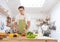 Happy caucasian couple family cooking in modern kitchen at home. woman wash dish at sink, man peel avocado while cooking fresh