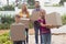 Happy Caucasian family holding cardboard boxes in home yard