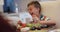 Happy caucasian grandson laughing at table, sitting beside grandfather during family meal