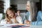 Happy caucasian little girl with elderly grandma with colorful pencils draw picture on table, enjoy study