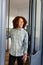 Happy caucasian man with curly hair welcoming at door at home