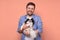 Happy caucasian man holding and comforting cute pet dogs japanese chin