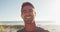 Happy caucasian man standing and smiling by the sea