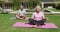 Happy caucasian senior couple practicing yoga meditating in garden in the sun