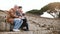 Happy Caucasian senior family with young daughter sitting and talking on amphitheater ruins in Ostia, Italy with a map.