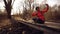 Happy caucasian woman cyclist makes a photo of herself a selfie on the phone while sitting on the bridge over a river in