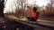 Happy caucasian woman cyclist makes a photo of herself a selfie on the phone while sitting on the bridge over a river in