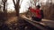 Happy caucasian woman cyclist makes a photo of herself a selfie on the phone while sitting on the bridge over a river in