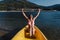 Happy caucasian woman holding oar sitting on yellow canoe in lake during sunny day. summer time. Sports, adventure and nature