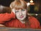 Happy caucasian woman leaning her head on her hand smiling looks at the camera with a calm look. Front view. Indoors