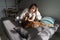 Happy Caucasian woman pet owner relaxing in bed with beloved dog in morning