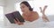 Happy caucasian woman relaxing, lying in bed and reading book